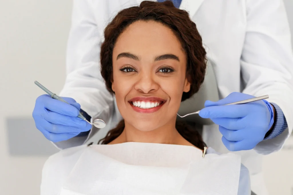 Happy patient displays her bright smile during dental examination at Great Neck practice.