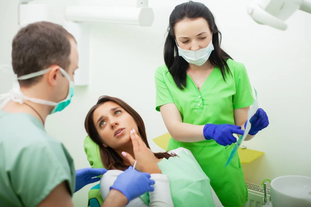 Dental professionals examining patient's swollen gums for abscess and emergency treatment.