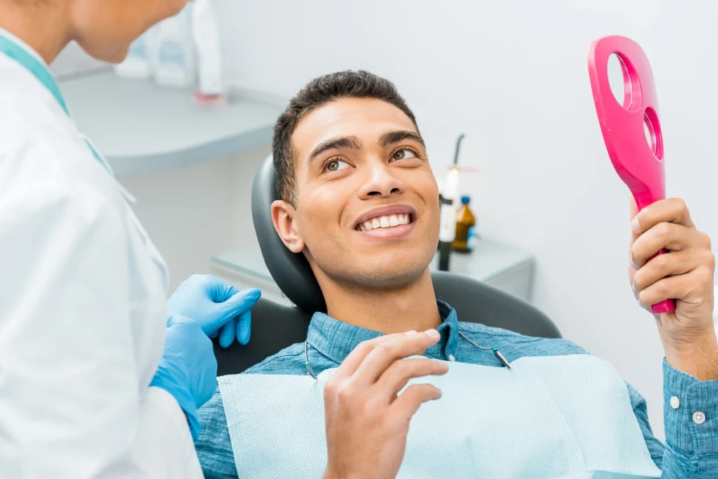 A scared female patient receiving emergency dental treatment from a dentist using a drill and explorer tool at an emergency dentist in Great Neck.