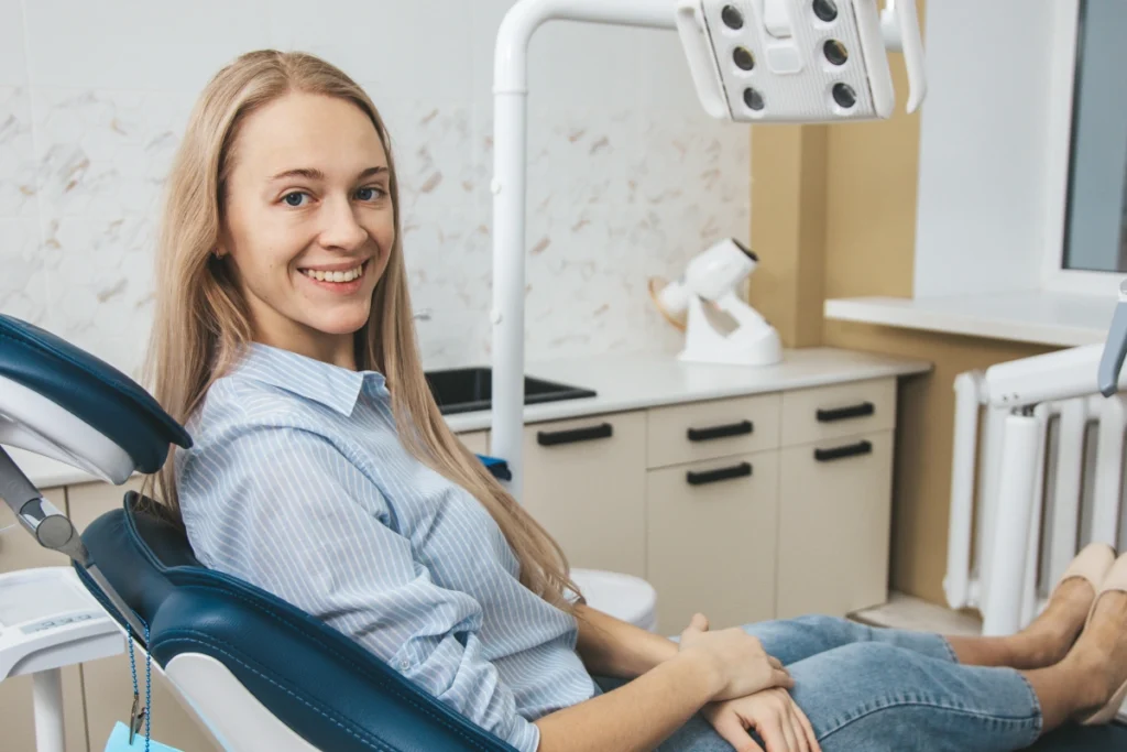 Smiling patient seated in dental chair at Great Neck practice.